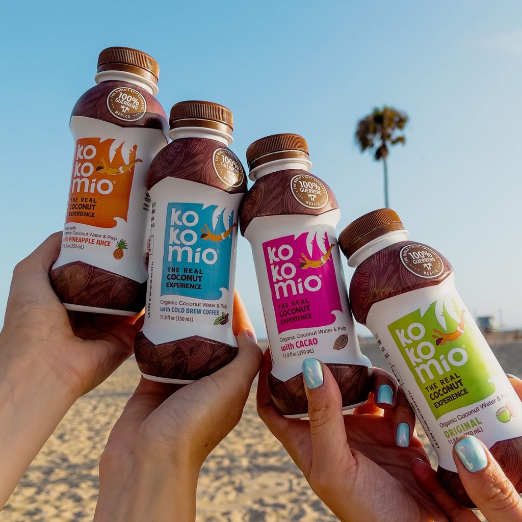 Hands holding up all four flavors at the beach